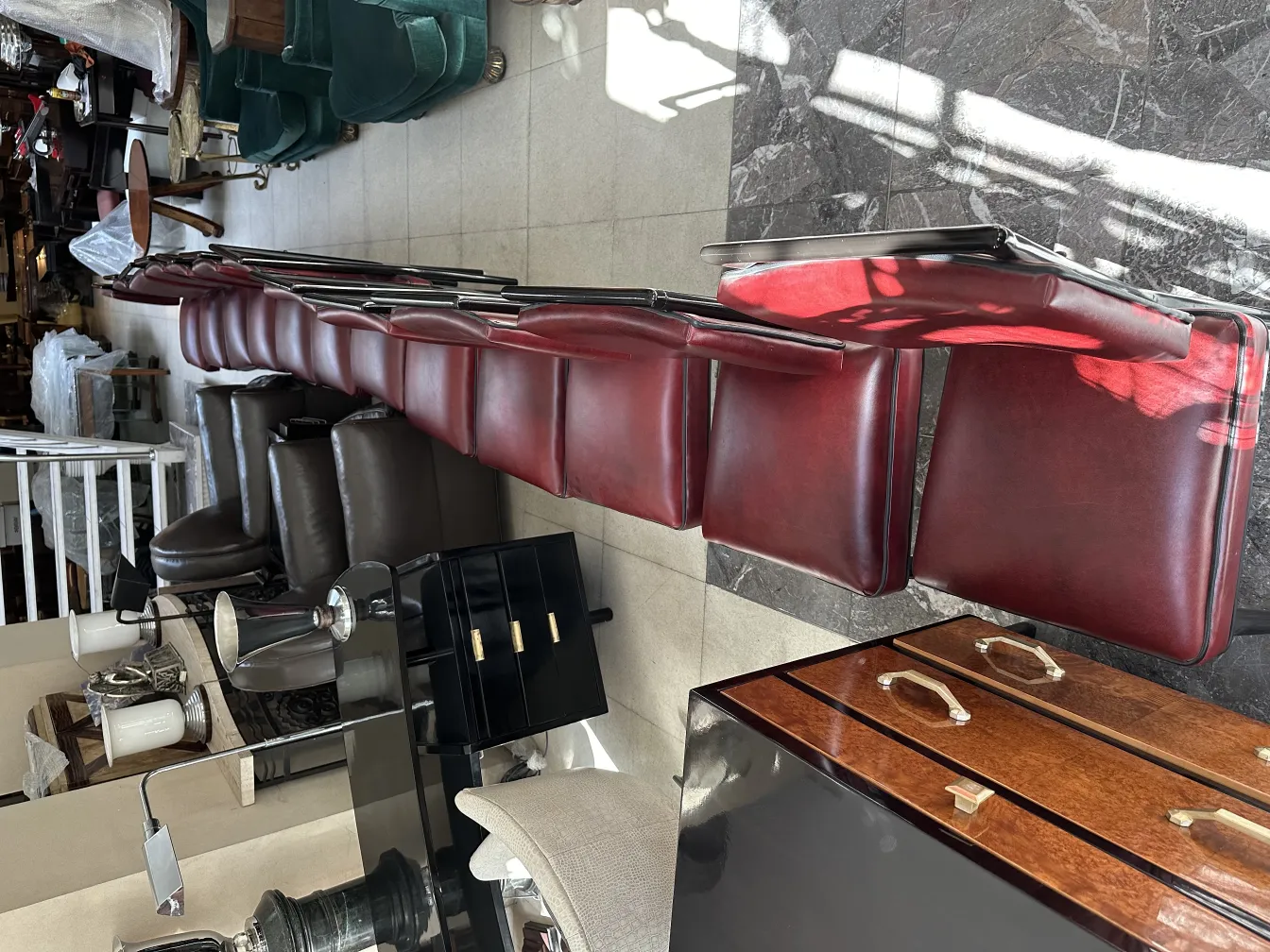 12 sedie antiche rosse allineate in un ambiente accogliente