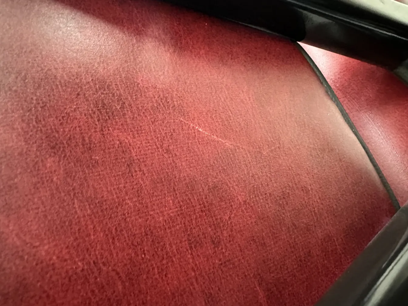 Close-up of 12 antique chairs in dark red, part of a classic setting.