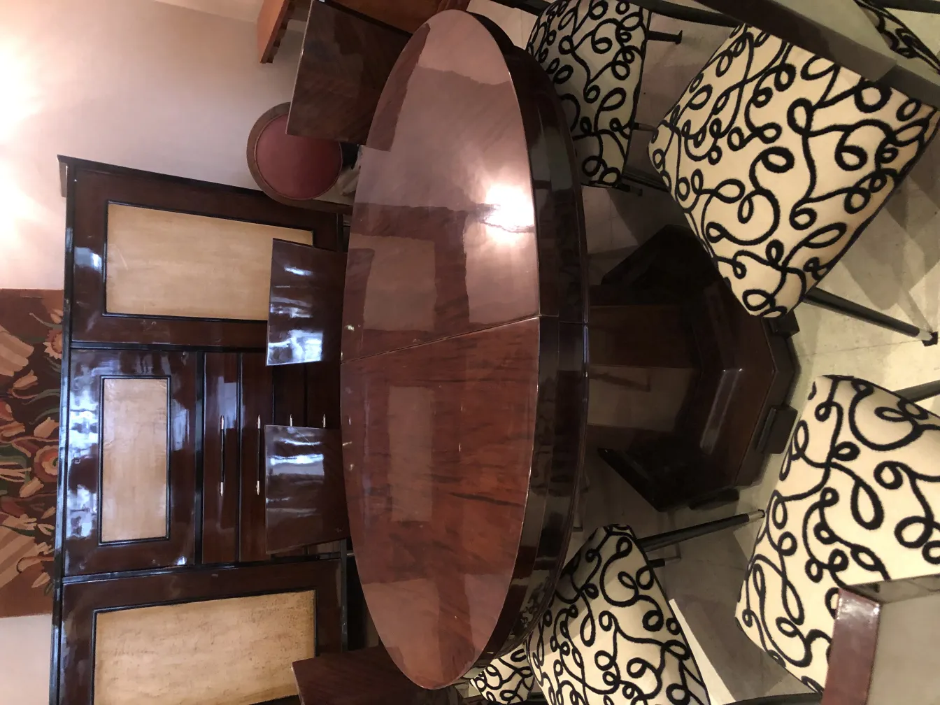 Vista de um conjunto de 12 cadeiras antigas com design decorativo em um ambiente elegante.