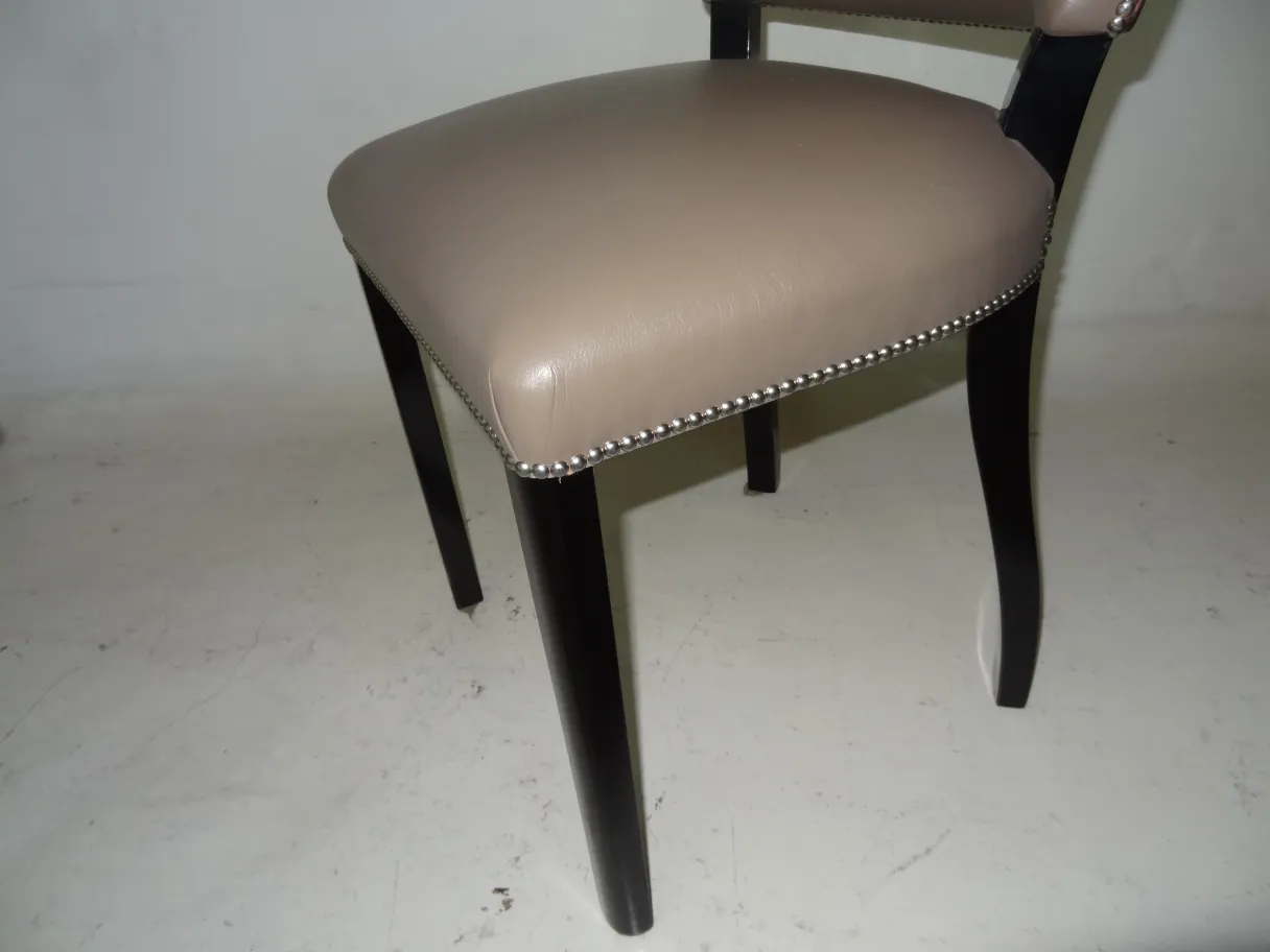 Chaises anciennes avec rembourrage clair, pieds noirs et perles décoratives