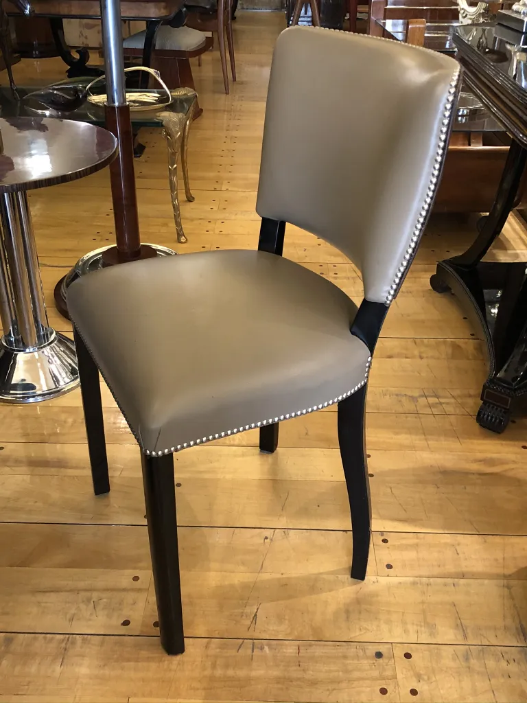 Uma cadeira antiga elegante com estofamento claro em um ambiente clássico