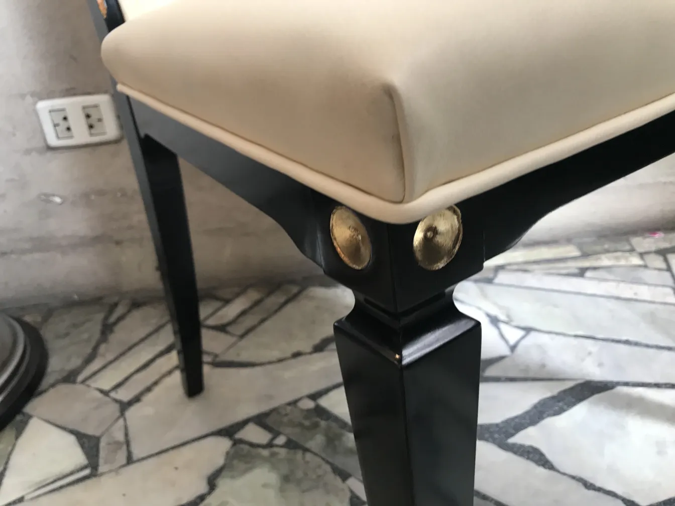 Close-up view of 12 antique chairs with cushions and gold detailing on the frame.