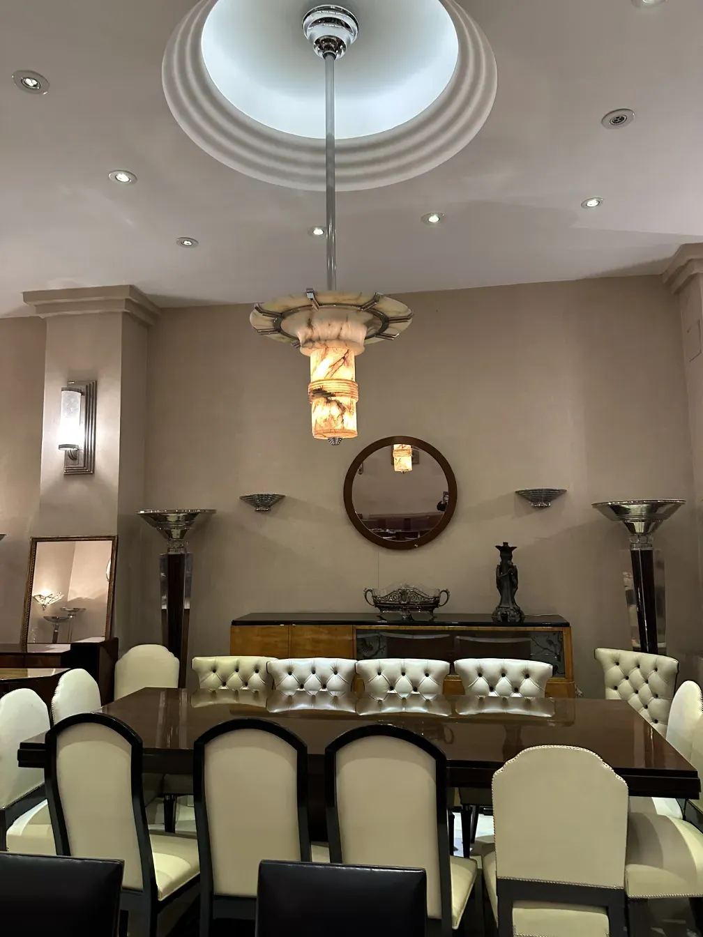 Juego de 12 sillas antiguas en un comedor elegante con espejo