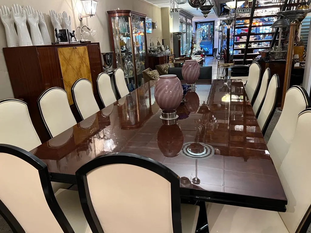 12 chaises anciennes autour d'une table à manger, décorées de vases