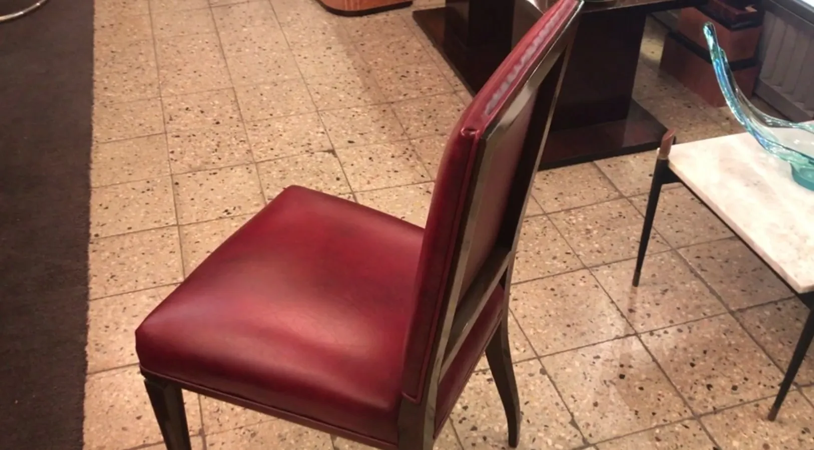 Vue latérale de 12 chaises anciennes dans un cadre chaleureux avec un sol carrelé