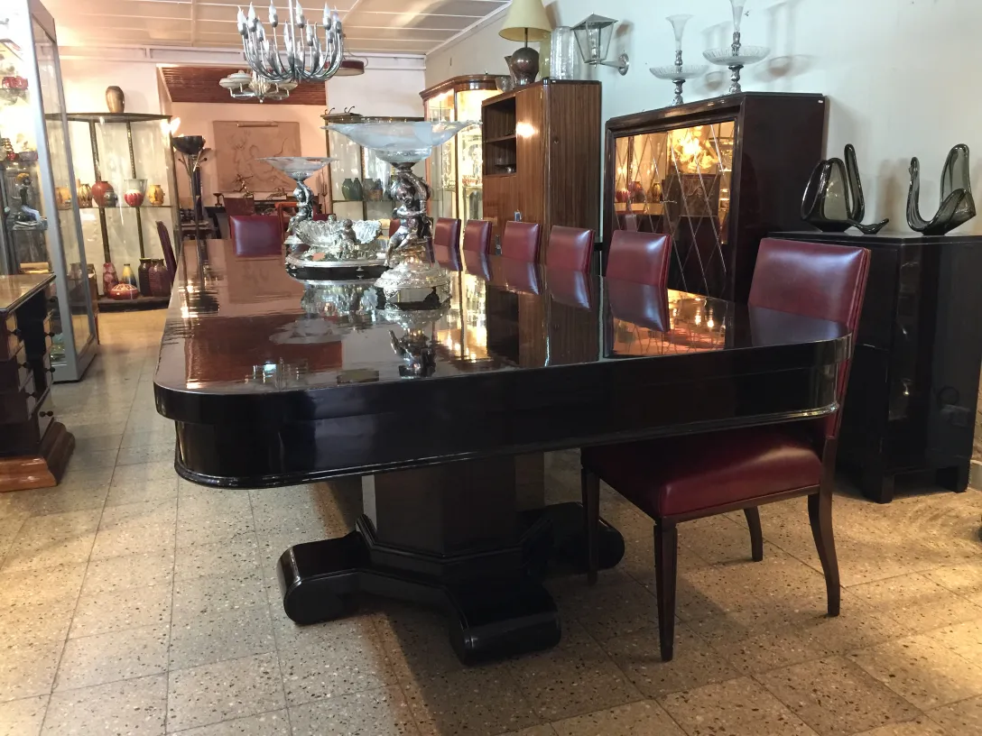 Ansicht von 12 eleganten antiken Stühlen um einen glänzenden Tisch in einer gemütlichen Umgebung.