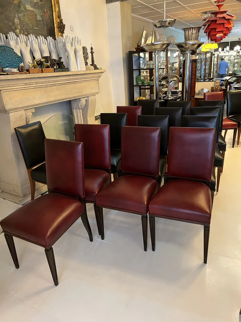 Set of 12 antique chairs, various in burgundy and black, in an elegant setting.
