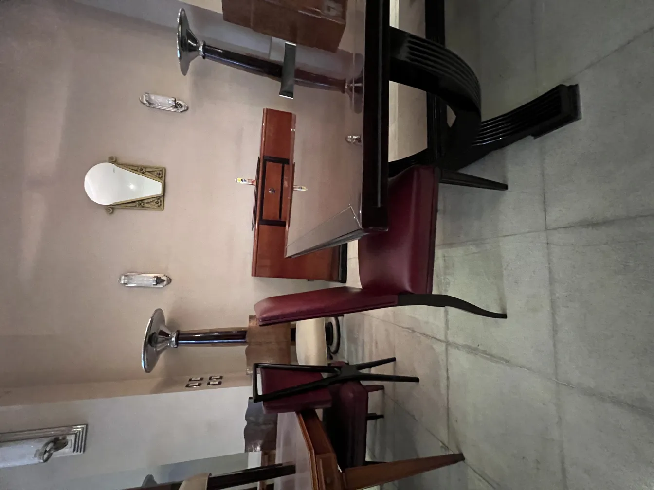 12 cadeiras antigas ao redor de uma mesa elegante em um ambiente aconchegante.