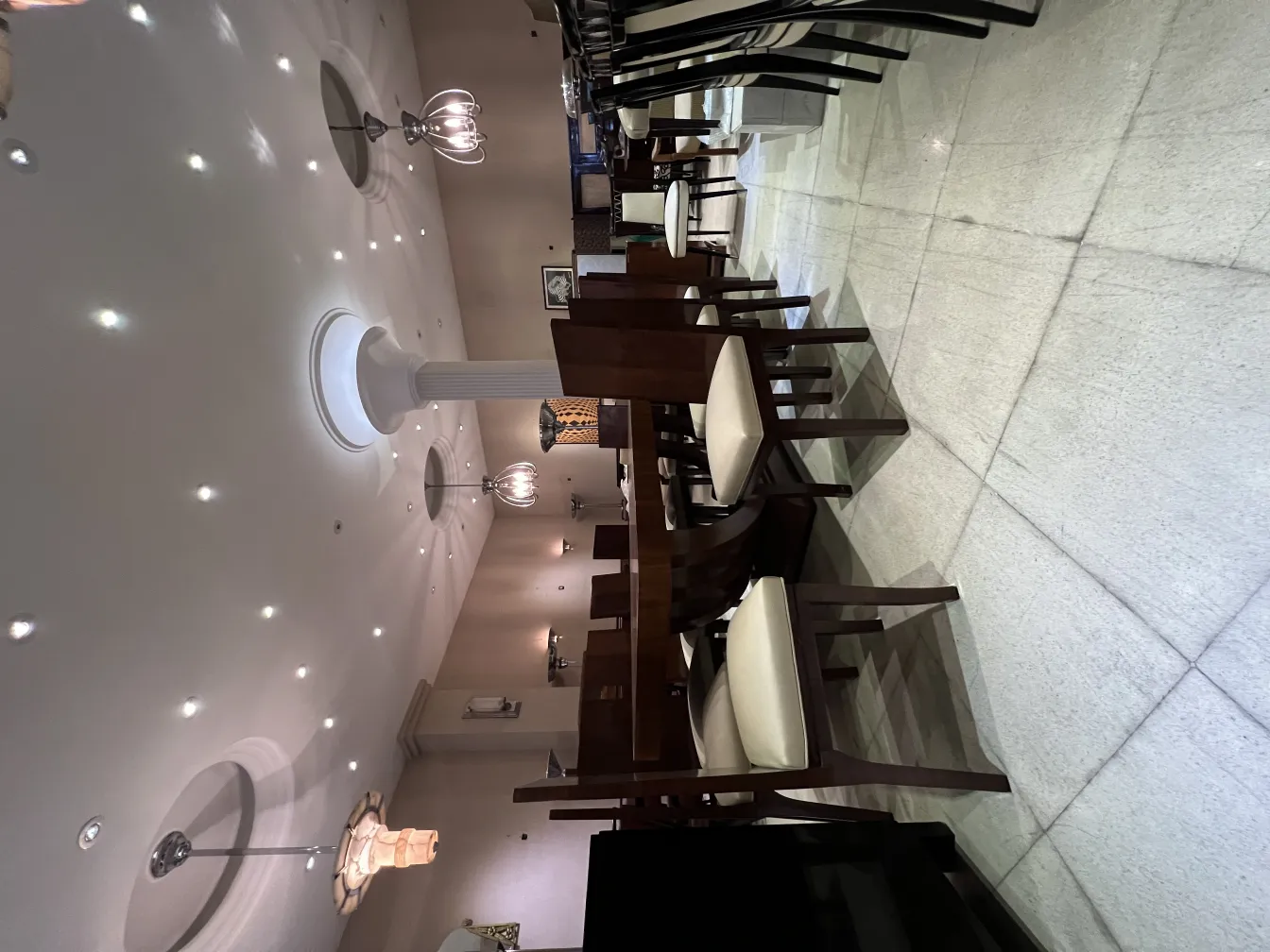 twelve antique chairs in an elegant setting with dim lighting