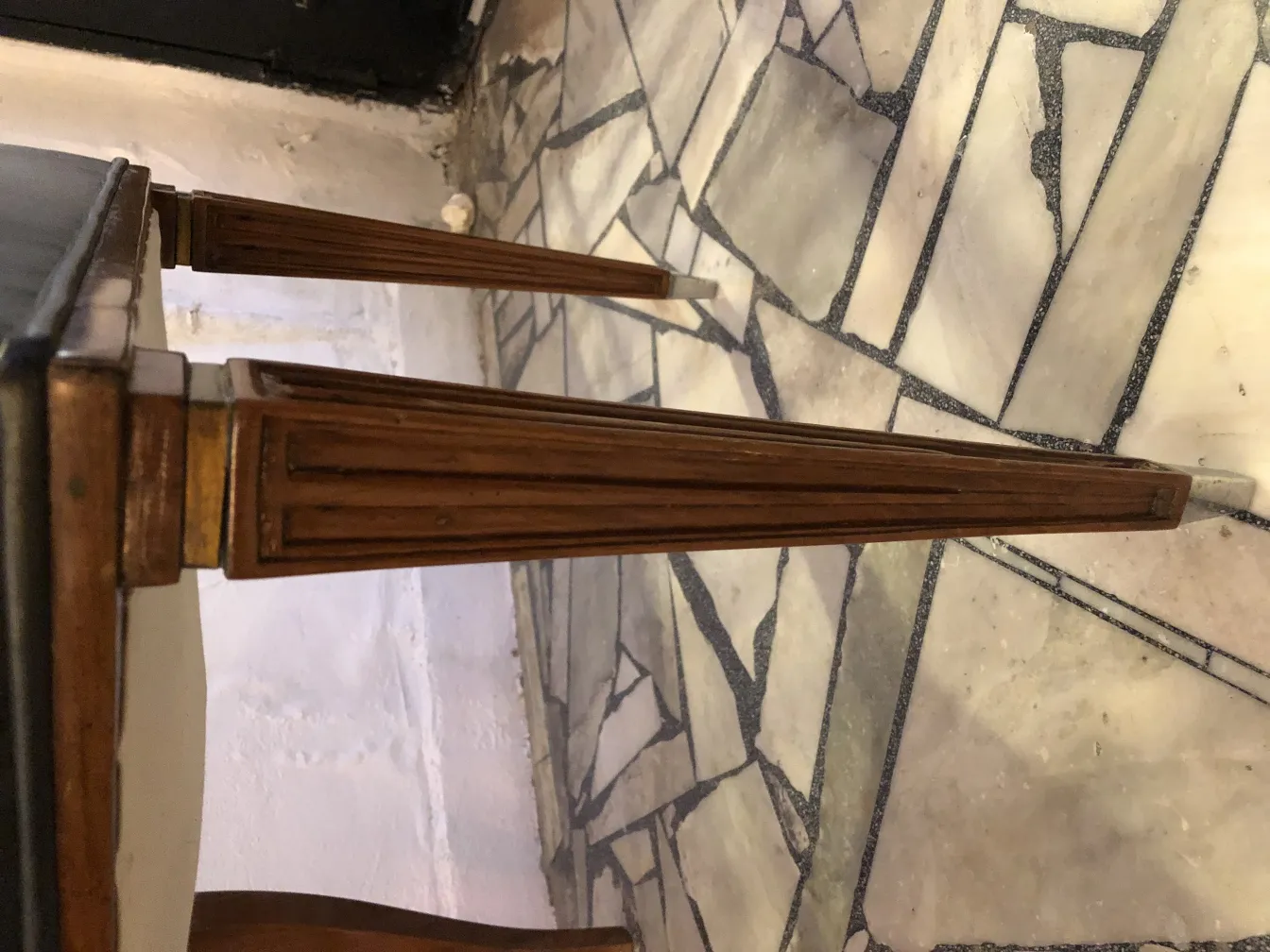 12 antique chairs with elegant legs on a stone floor