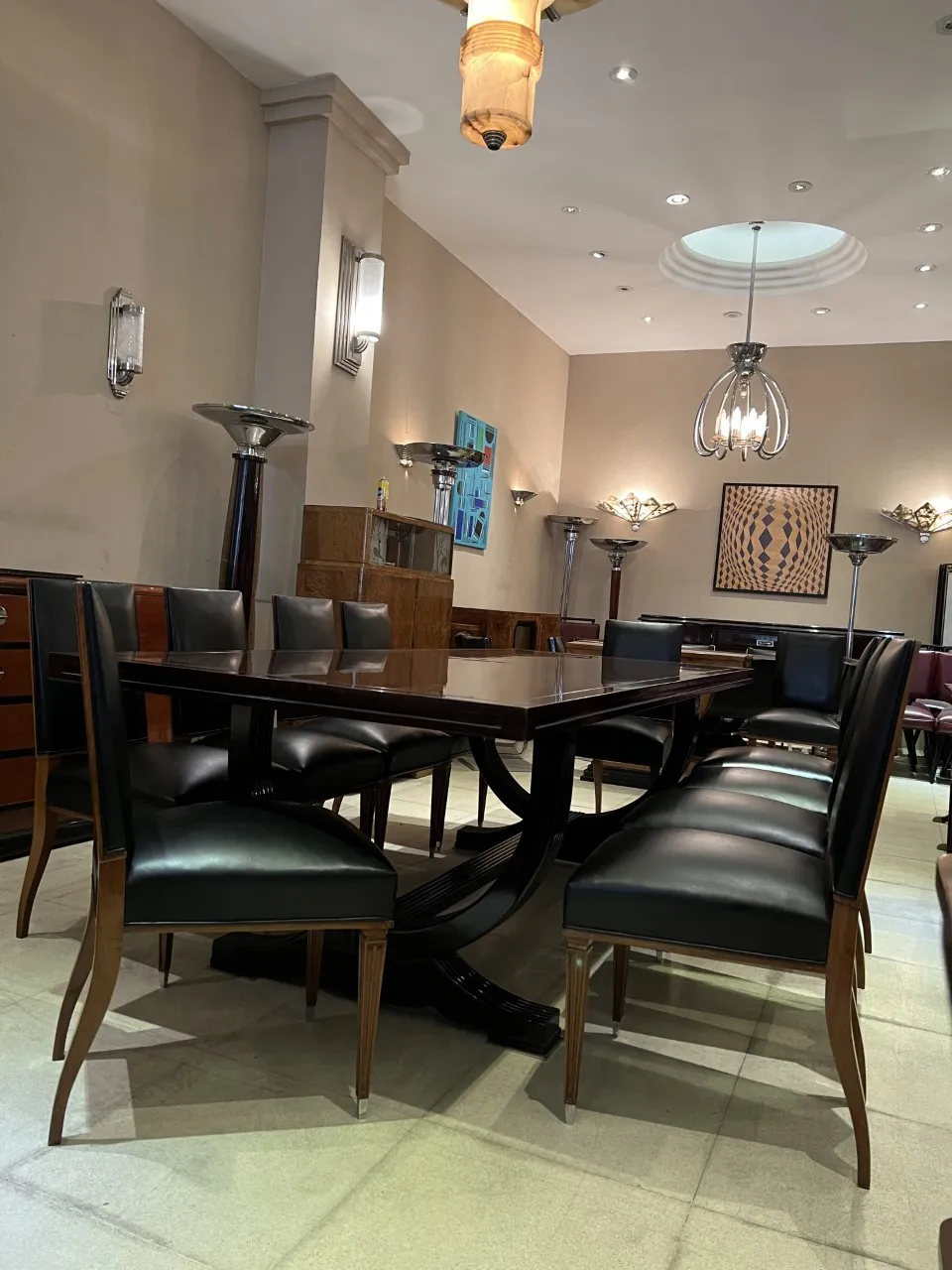 Douze chaises anciennes élégantes disposées autour d'une table à manger moderne.