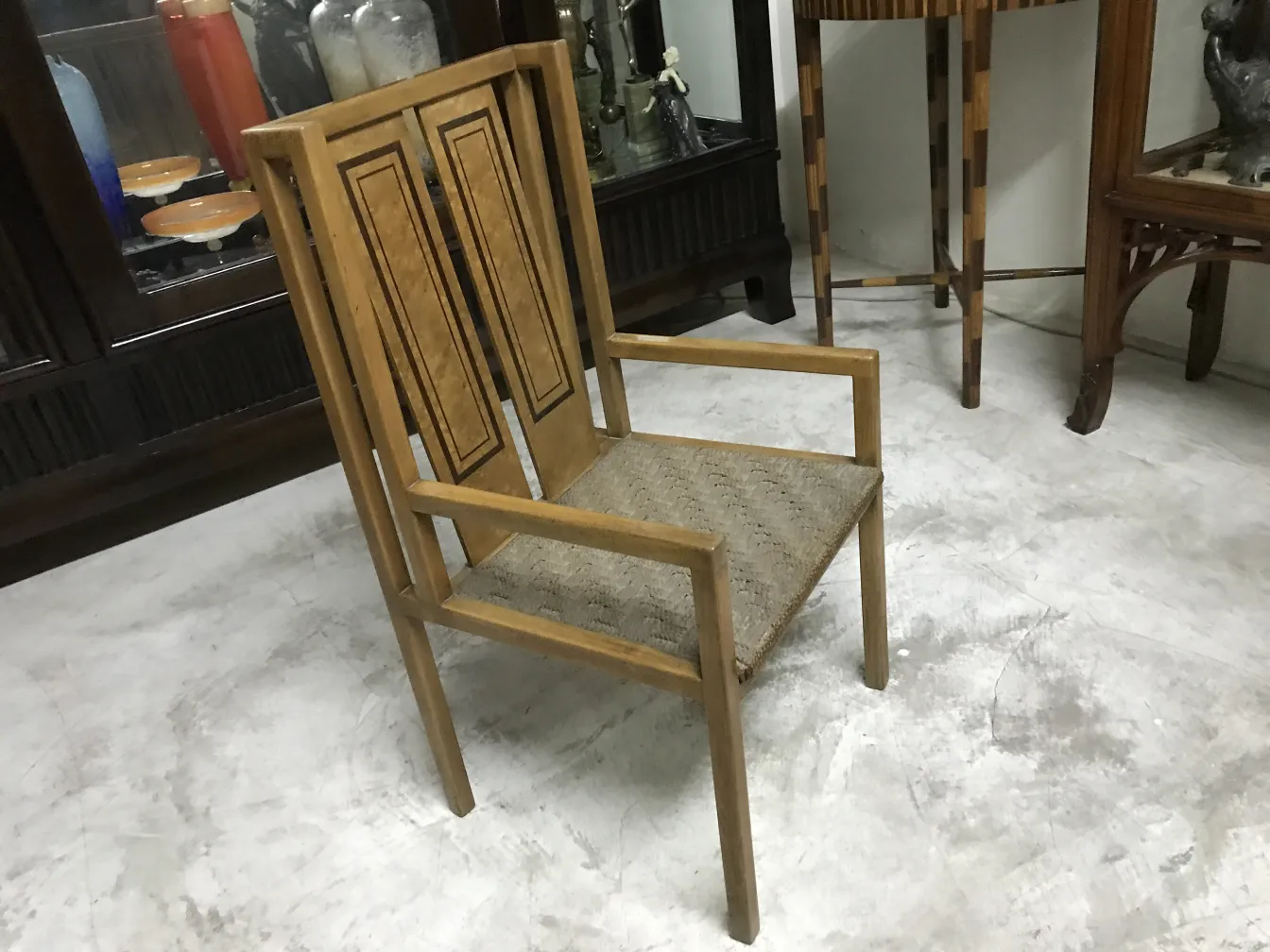 Antique chair with straight backrest and comfortable seat, well-lit background.