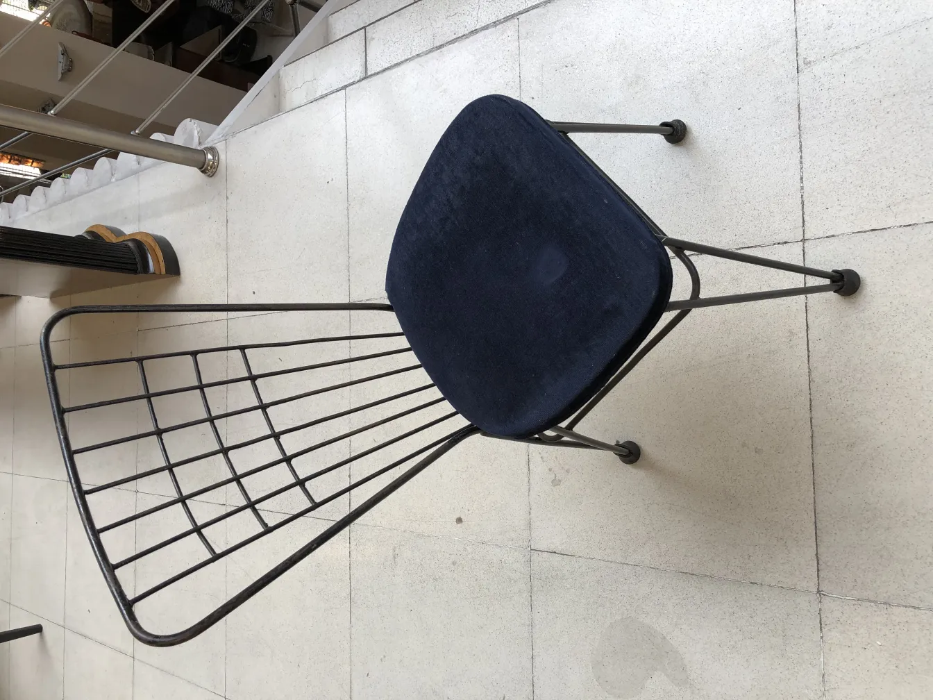 Silla antigua de color azul, forma estilizada, en un ambiente moderno.