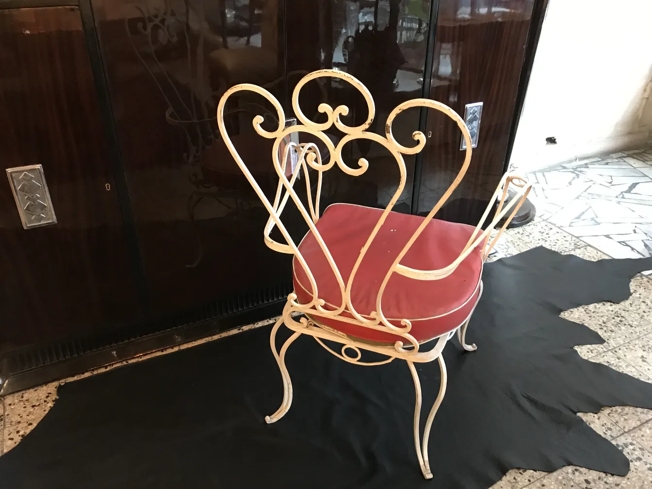 Poltrona de jardim antiga com design elegante e encosto curvado em um ambiente aconchegante.