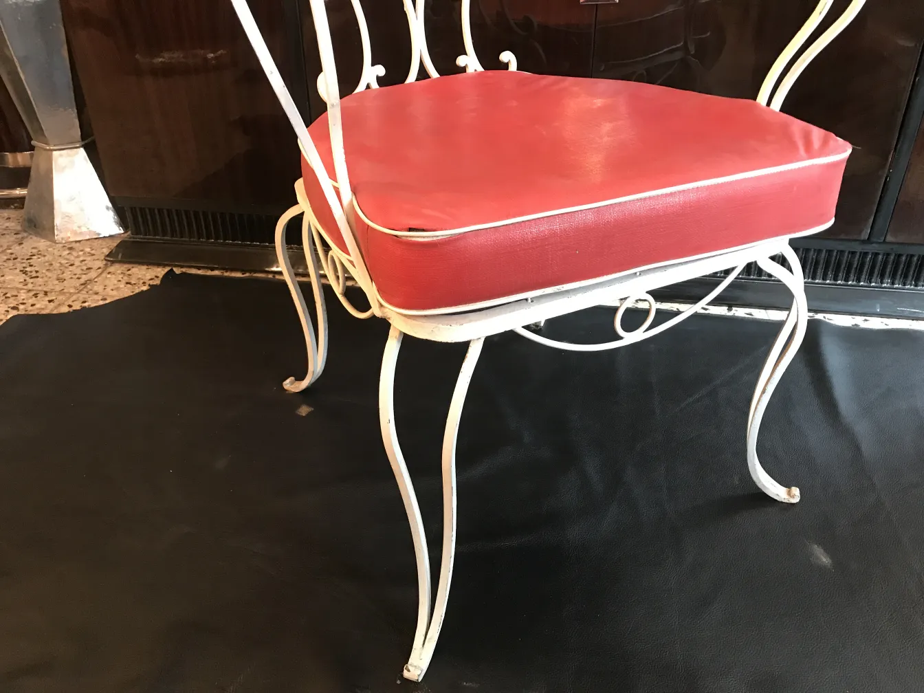 Antique garden armchair with red cushion in a cozy setting