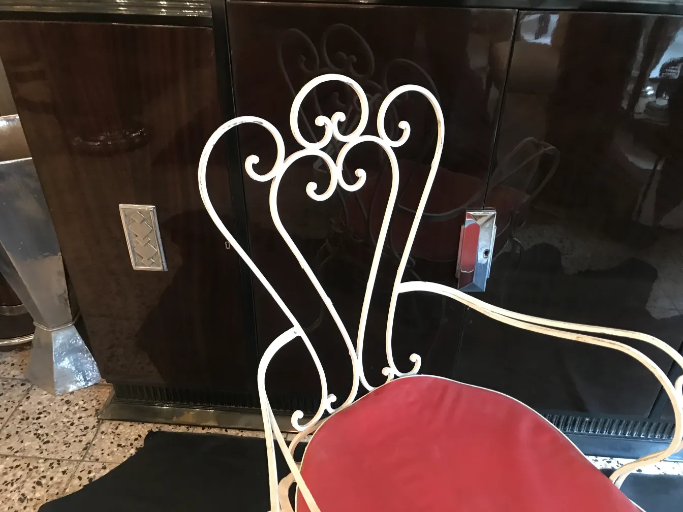 Poltrona de jardim antiga com design elegante e detalhes coloridos, em um ambiente aconchegante e decorativo.