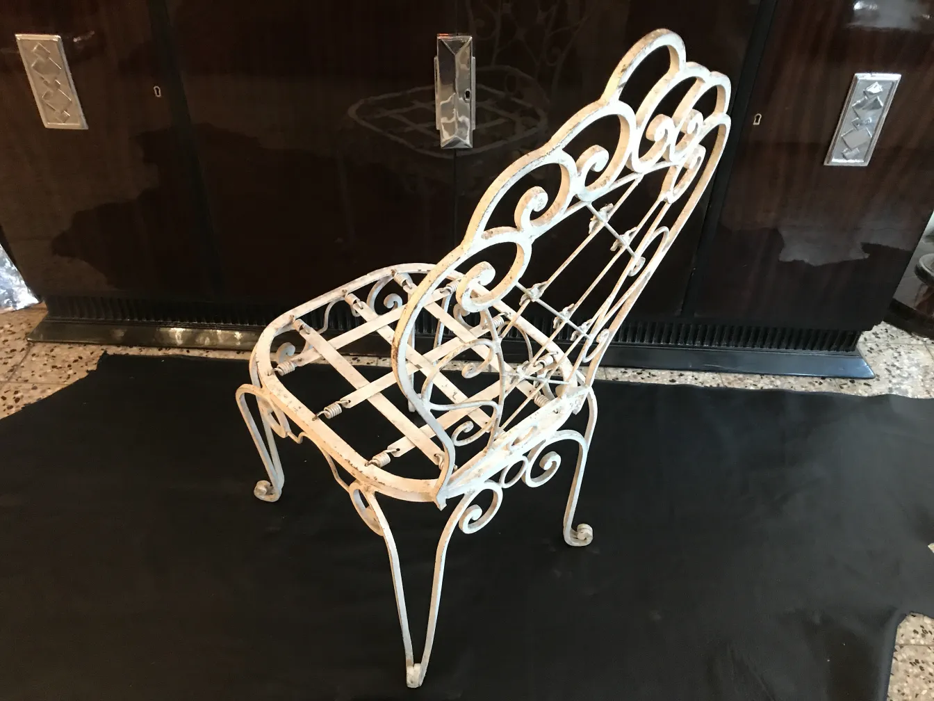 2 antique garden chairs with decorative white design, dark background