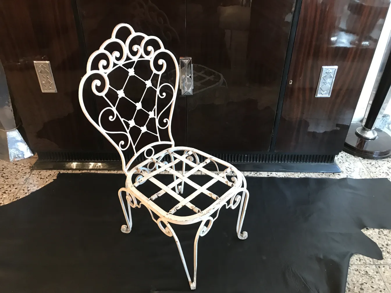 Zwei weiße antike Gartenstühle mit elegantem Design in einer gemütlichen Umgebung.