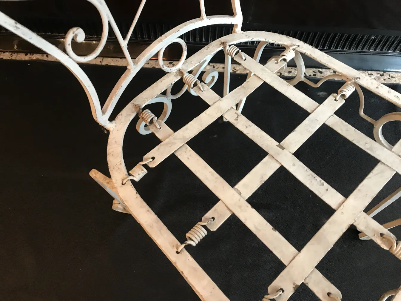 Vue détaillée de 2 chaises de jardin anciennes avec dossiers courbés, dans un cadre sombre.