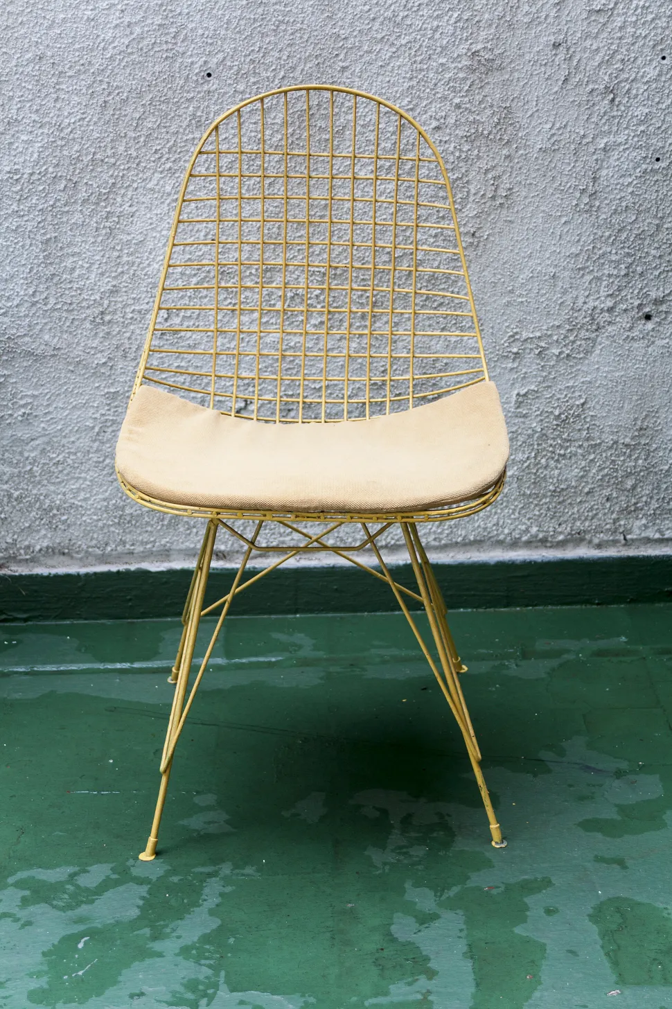 부드러운 패딩이 있는 고대 정원 안락의자, 노란색, 녹색 환경 속에.