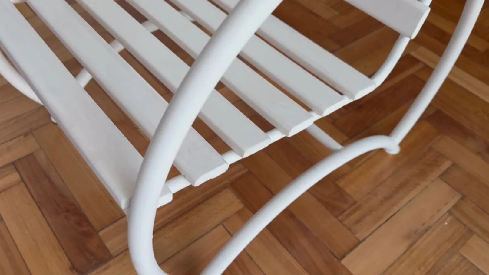 Dos sillones de jardín antiguos de color blanco, con un diseño simple y elegante, en un ambiente acogedor