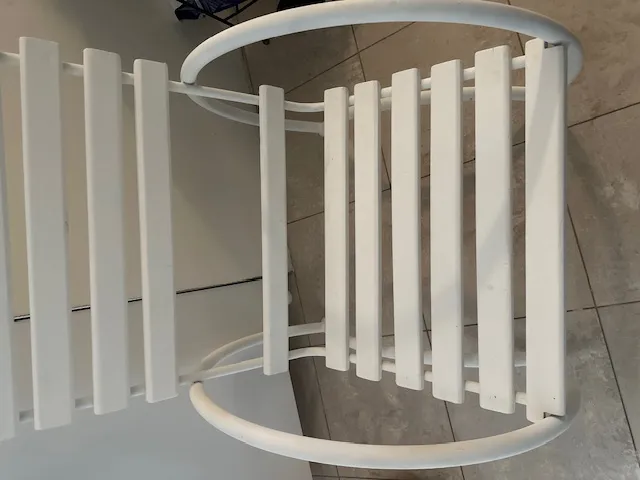 Deux fauteuils de jardin antiques blancs dans un cadre moderne.