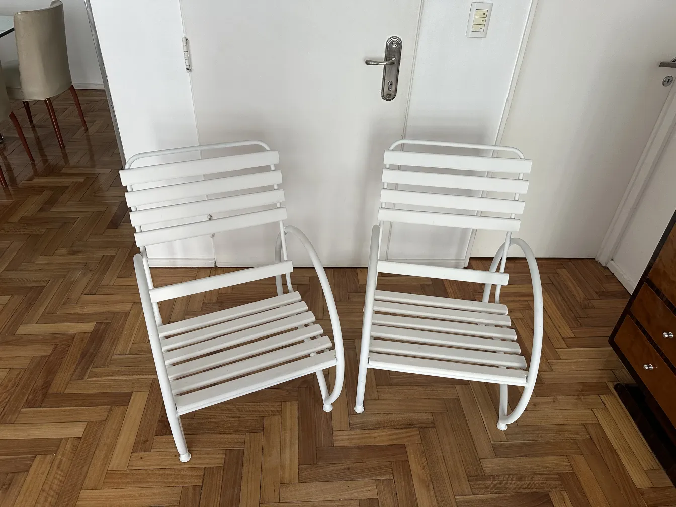 Deux fauteuils de jardin antiques blancs dans un environnement intérieur