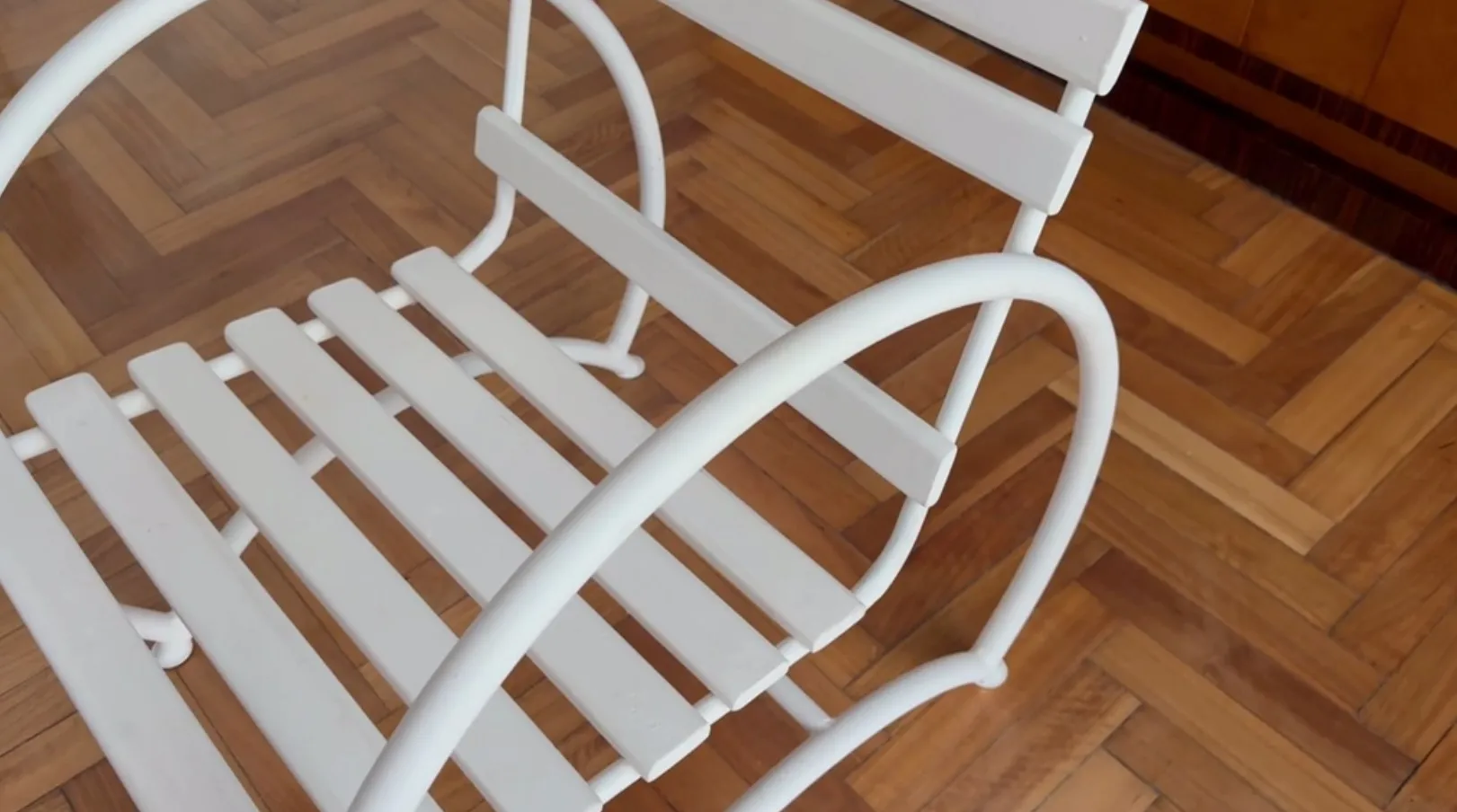 シンプルなデザインの古いガーデンアームチェア、薄い木の背景。