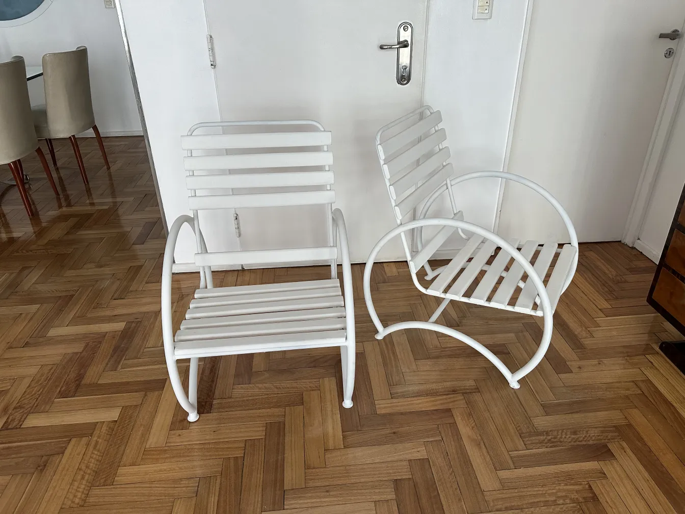 一组白色古董花园扶手椅，背景现代。