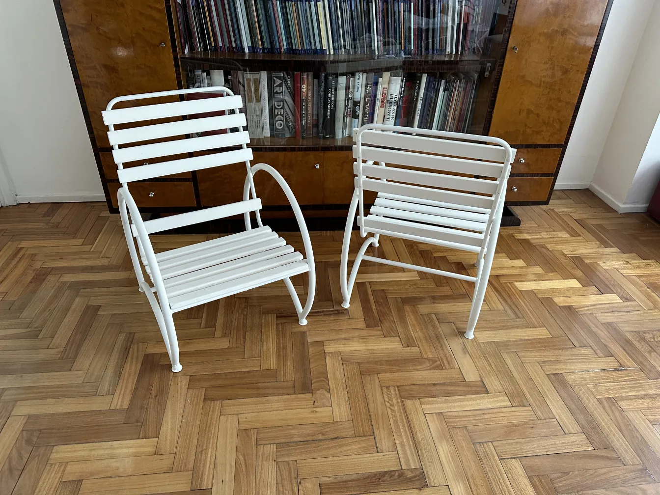 Due poltrone da giardino antiche in un ambiente accogliente, tonalità chiare e un elegante pavimento in legno.