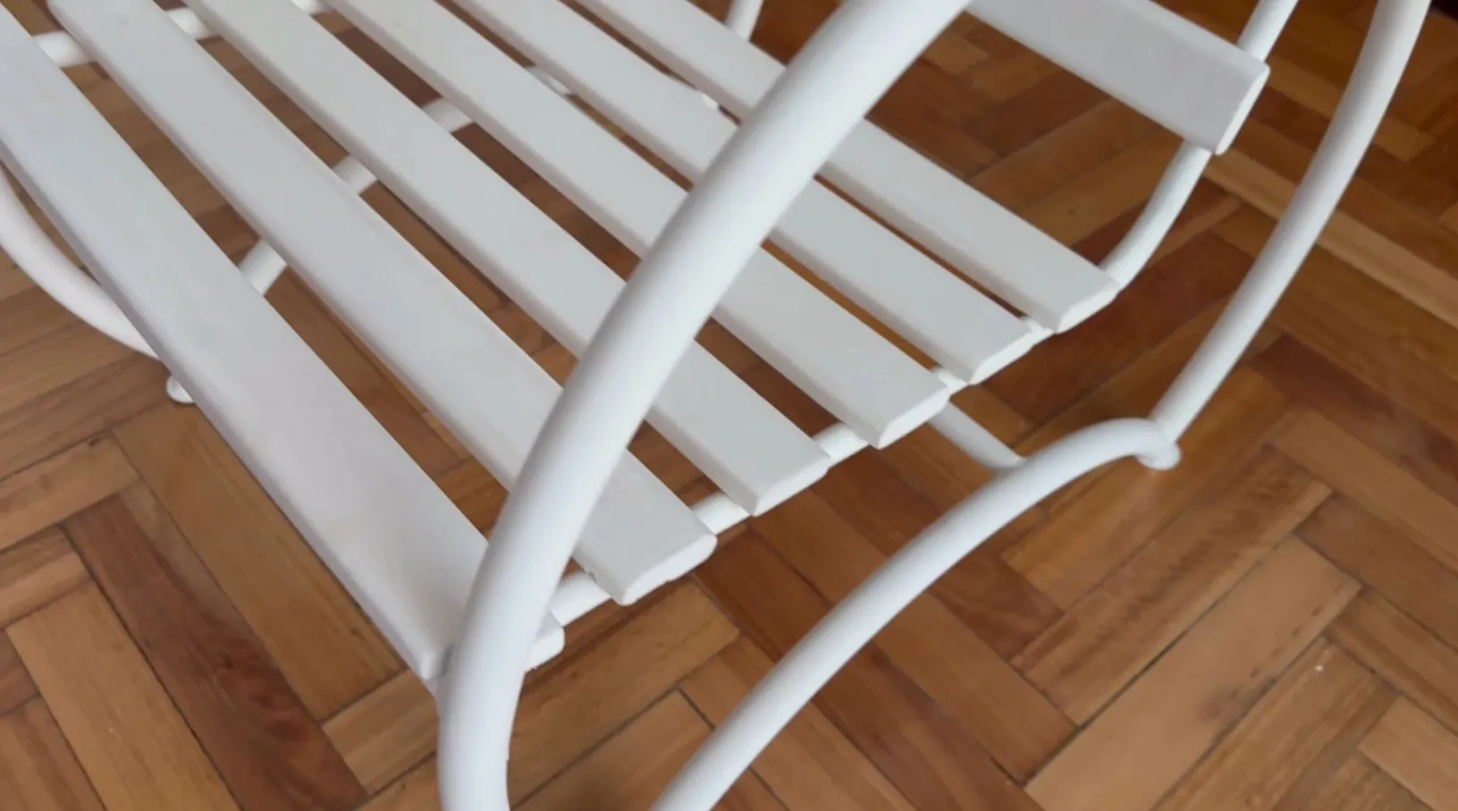 In un ambiente accogliente, si vedono 2 poltrone da giardino antiche di colore bianco, perfette per rilassarsi