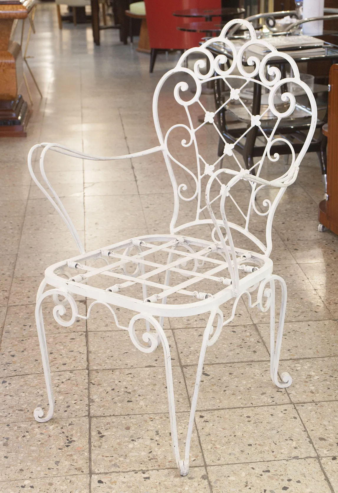 dos sillones de jardín antiguos con un diseño intrincado en un ambiente de antigüedades.