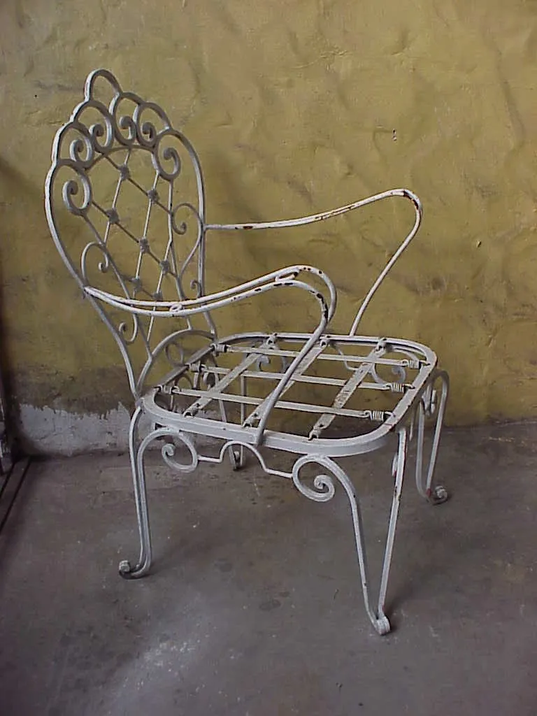 Poltronas de jardim antigas com design de treliça em um ambiente simples.