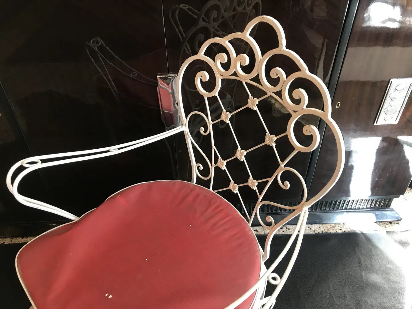 due poltrone da giardino antiche con cuscini rossi e design decorativo in un ambiente classico