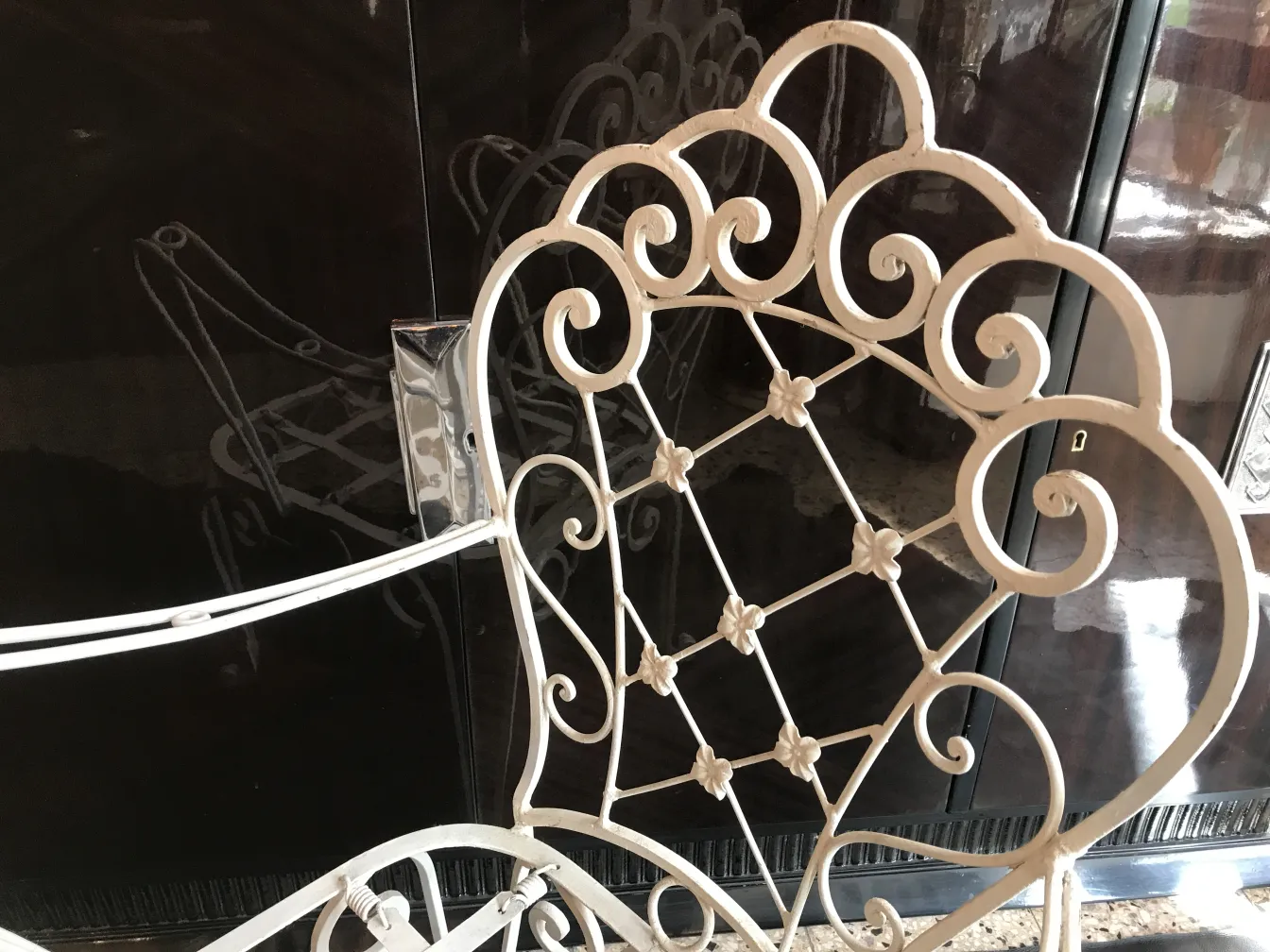 Coleção de antiguidades com duas poltronas de jardim e detalhes decorativos.