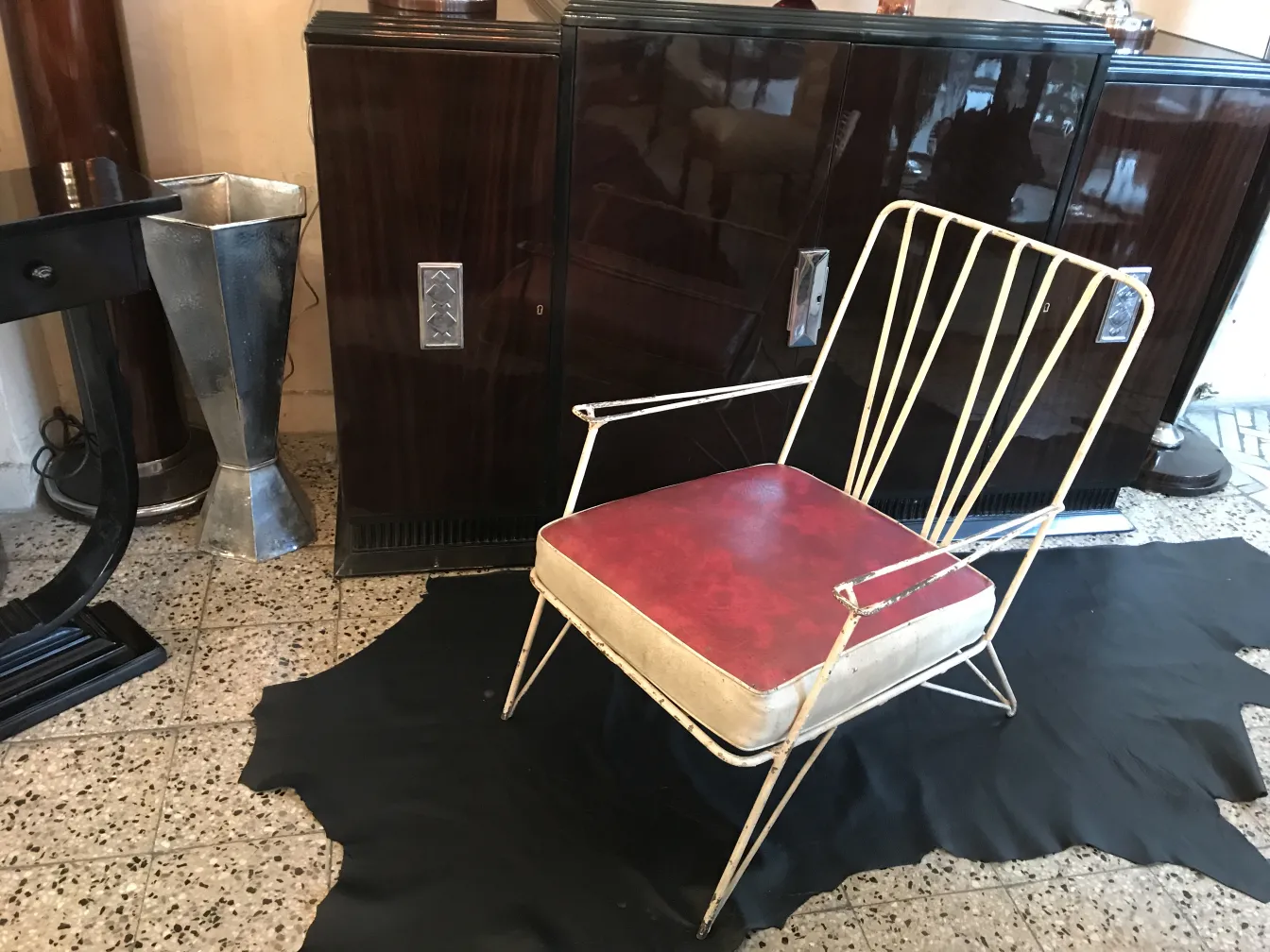 Deux fauteuils de jardin anciens avec des coussins rouges, arrière-plan avec des meubles vintage.