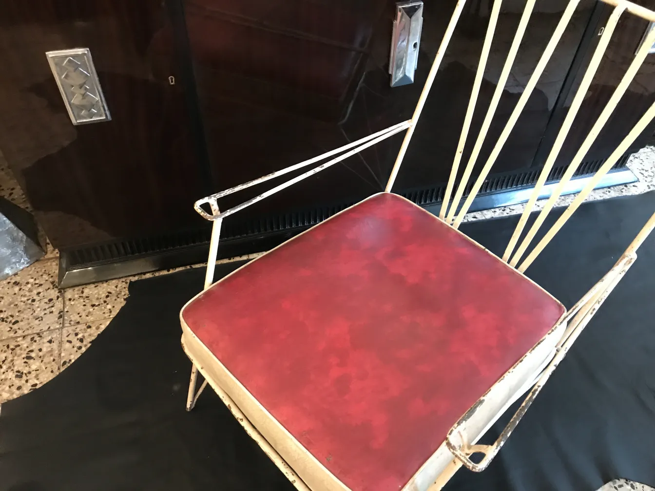 Deux fauteuils de jardin anciens avec un coussin rouge et un design élégant.