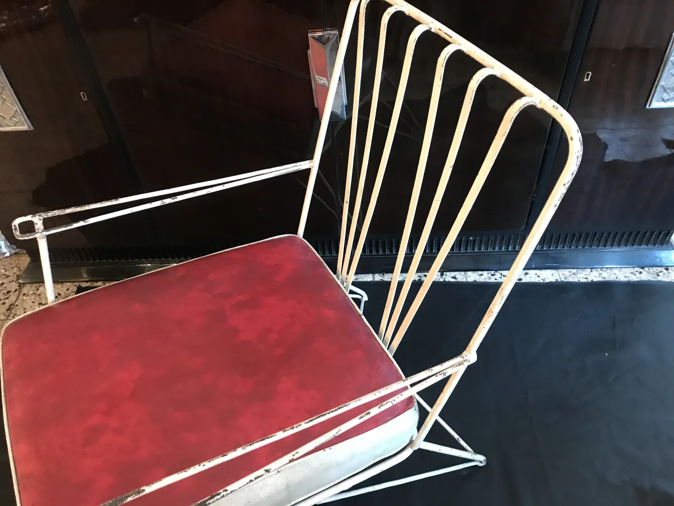 two antique garden armchairs with red cushions, in a stylish setting
