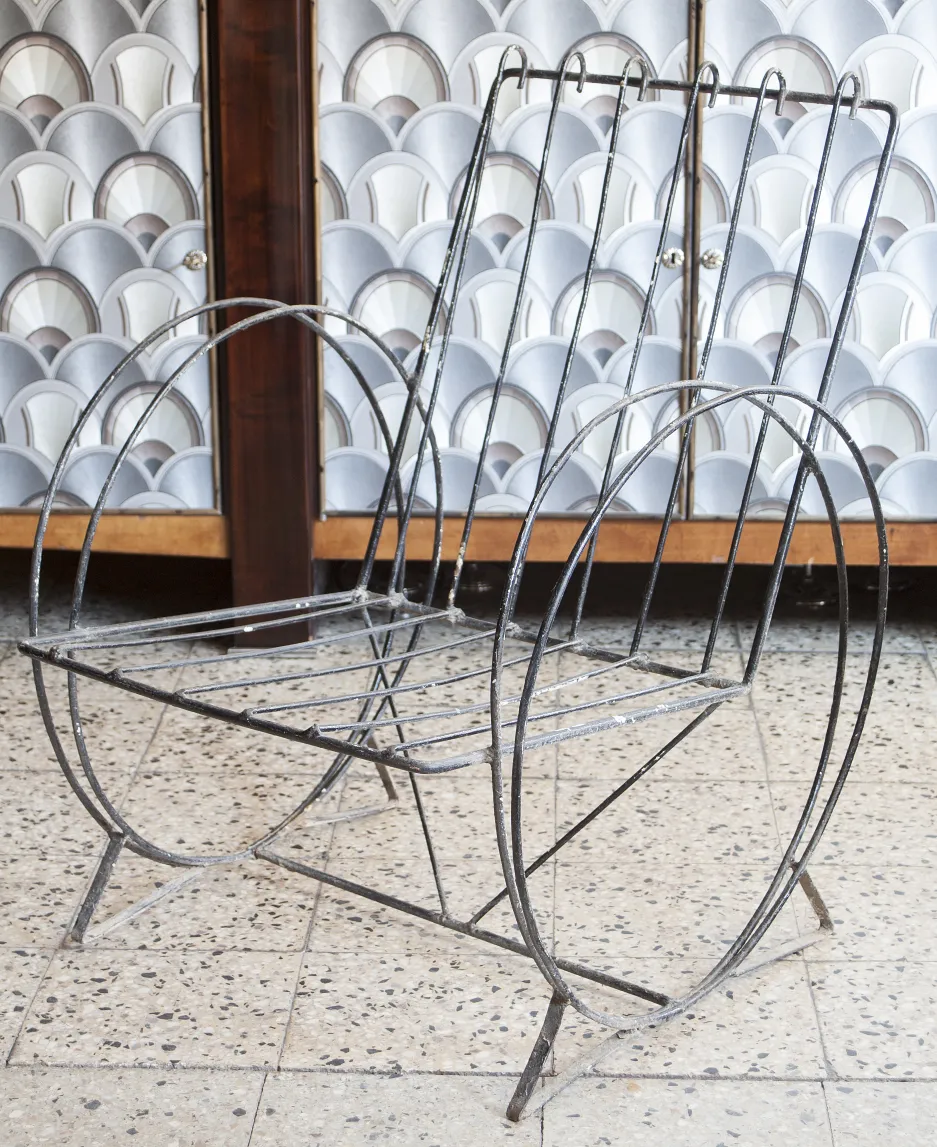 Due poltrone da giardino antiche con design elegante, sfondo neutro.