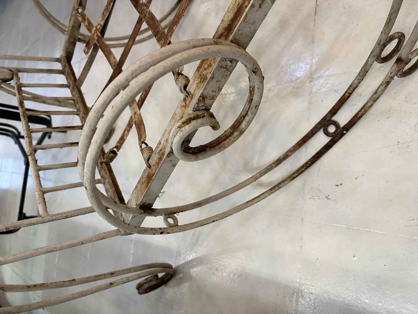 Três poltronas de jardim antigas com design curvado e estilo decorativo.