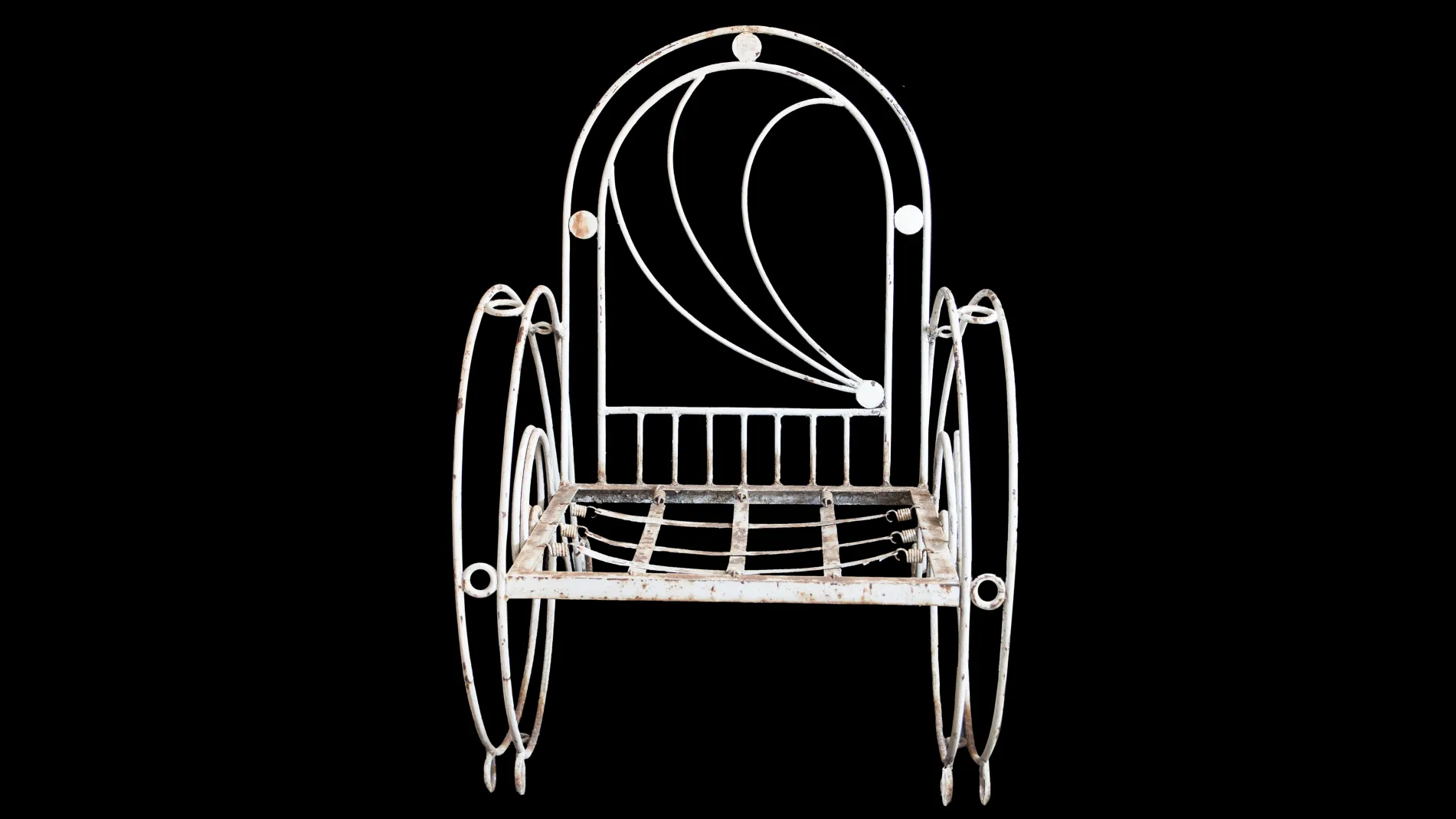 Tres sillones de jardín antiguos con un diseño elegante sobre un fondo negro.