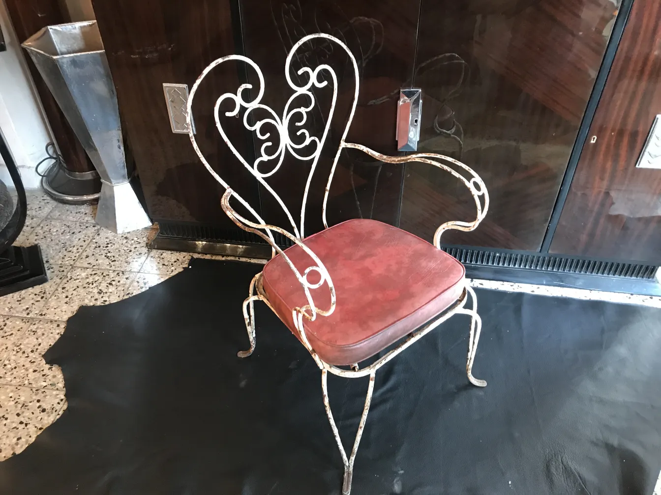 Três poltronas de jardim antigas com estilo decorativo, almofadas vermelhas, em um ambiente elegante.