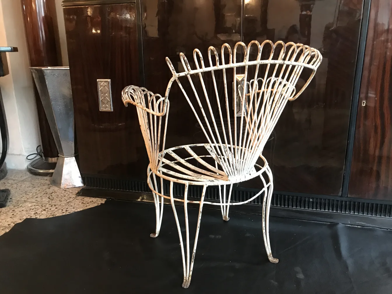 Quatre fauteuils de jardin anciens avec un design distinctif dans un cadre élégant.