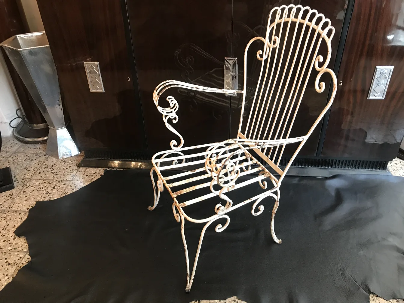 Quattro poltrone da giardino antiche con design elegante in un ambiente classico.