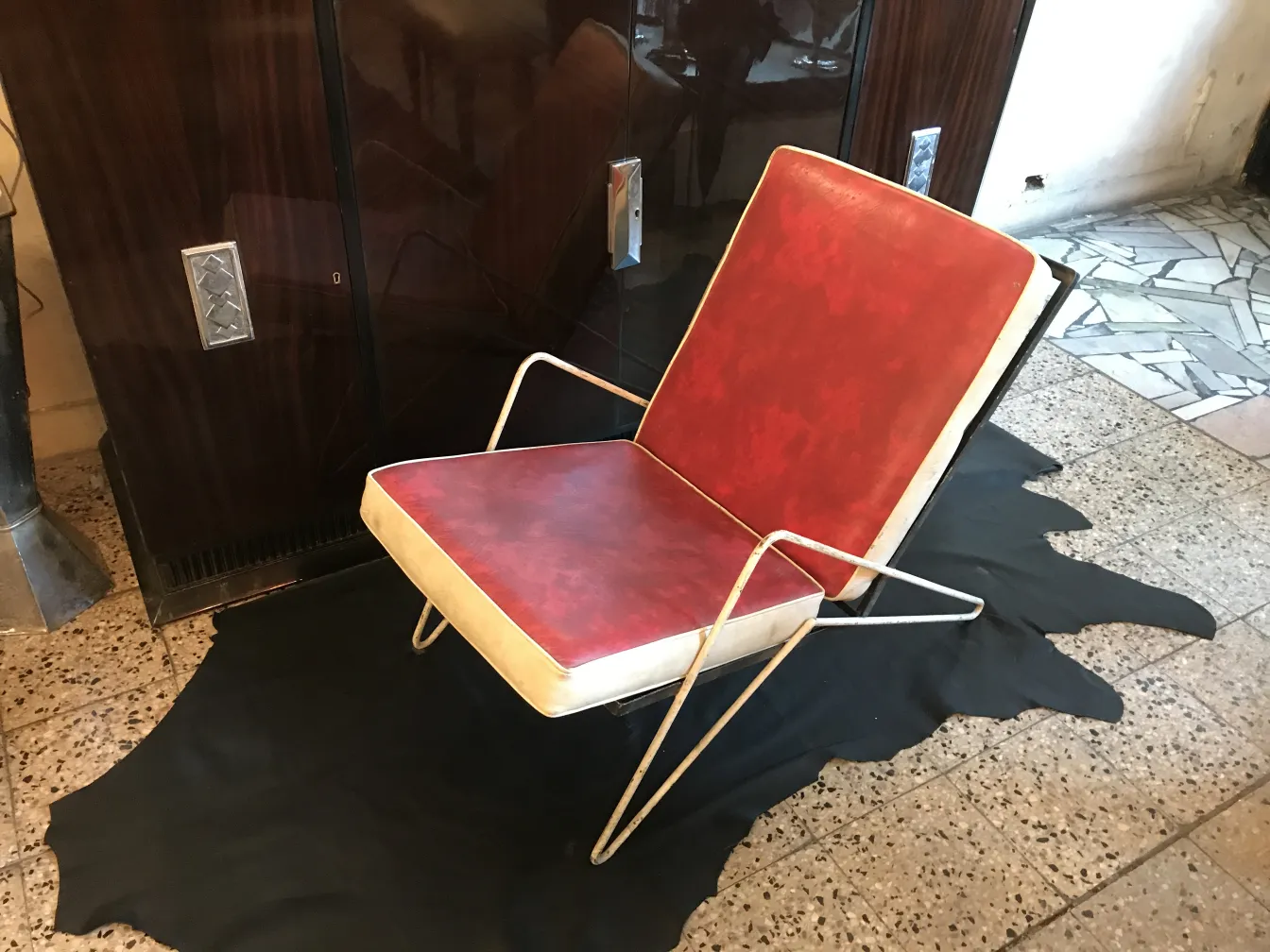 4 poltrone da giardino antiche con schienale rosso e base metallica, in un ambiente accogliente