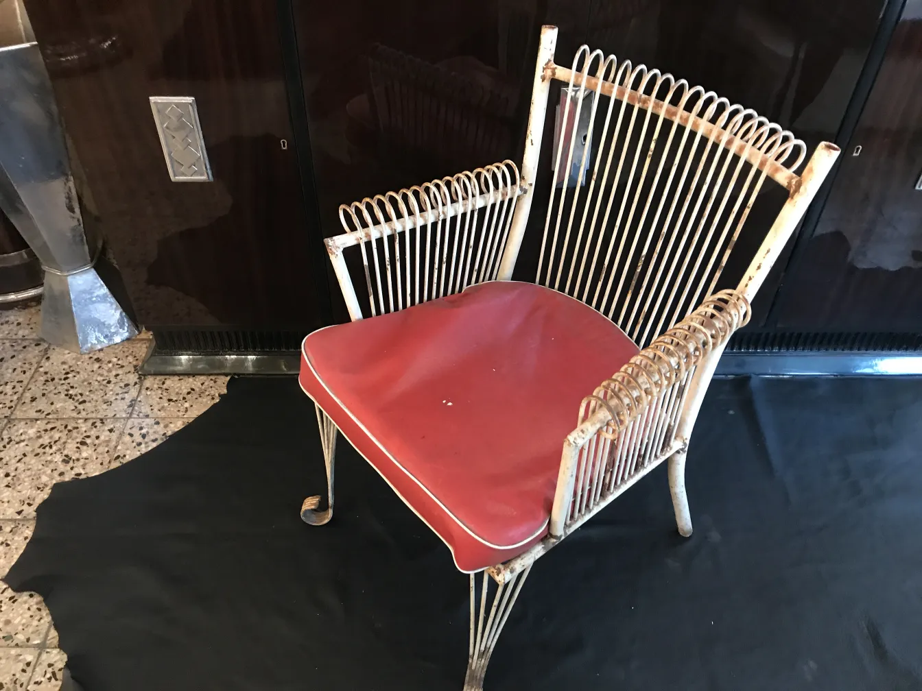 quatre anciens fauteuils de jardin avec des coussins rouges