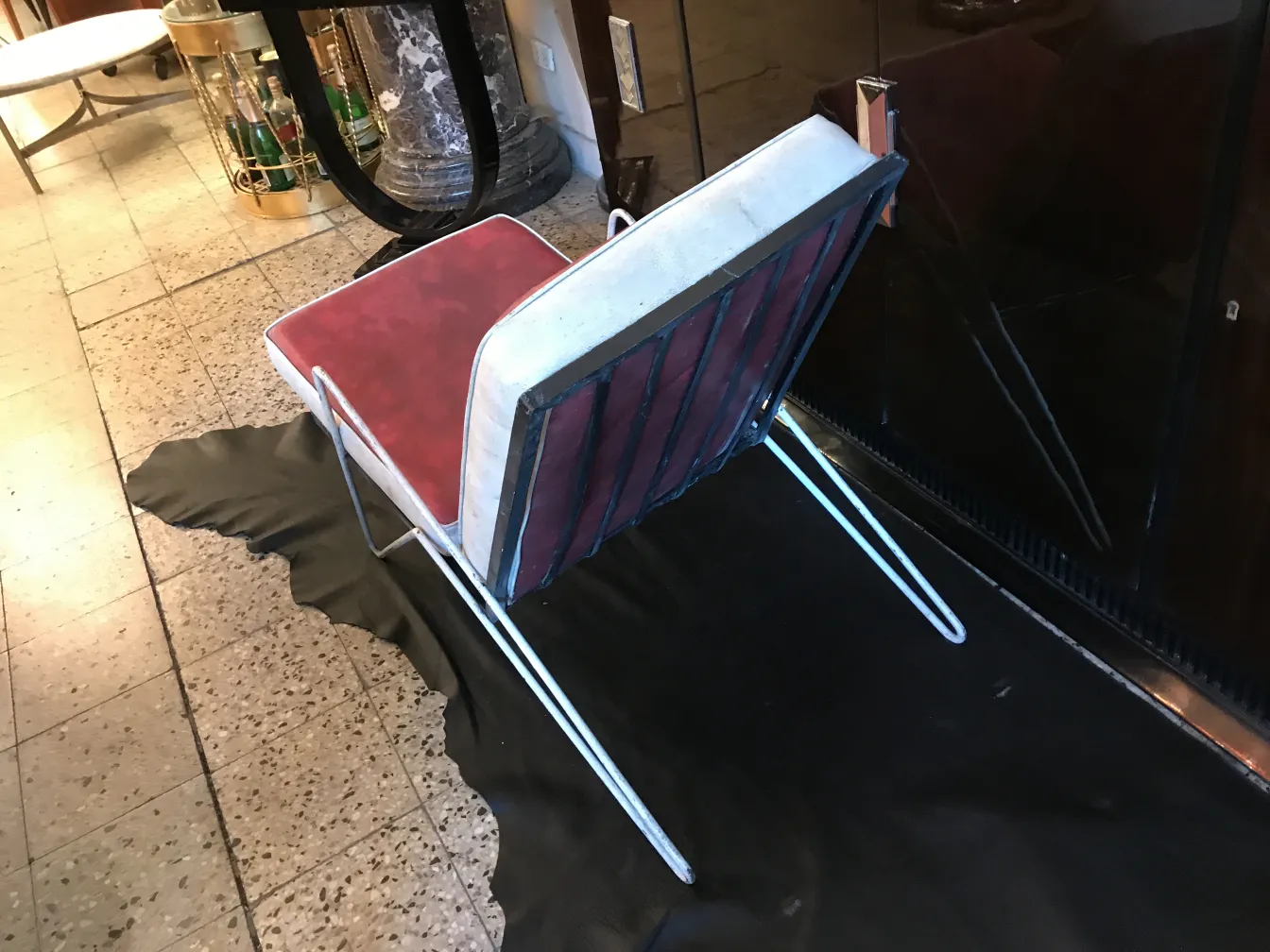 4脚の古いガーデンアームチェア、赤いクッションと白い背もたれがある、エレガントな環境で