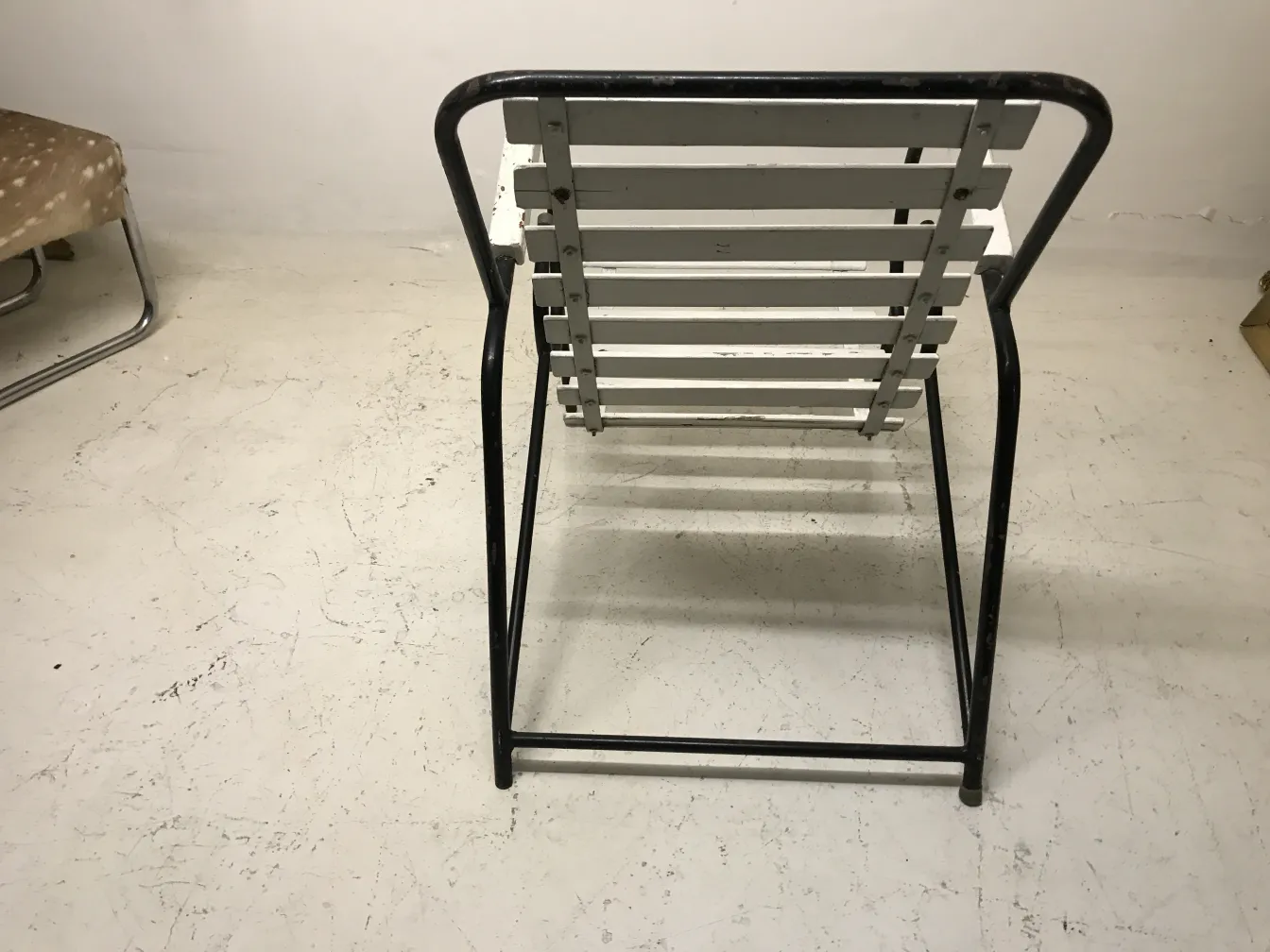 Antique garden armchairs with metal frame in neutral setting.