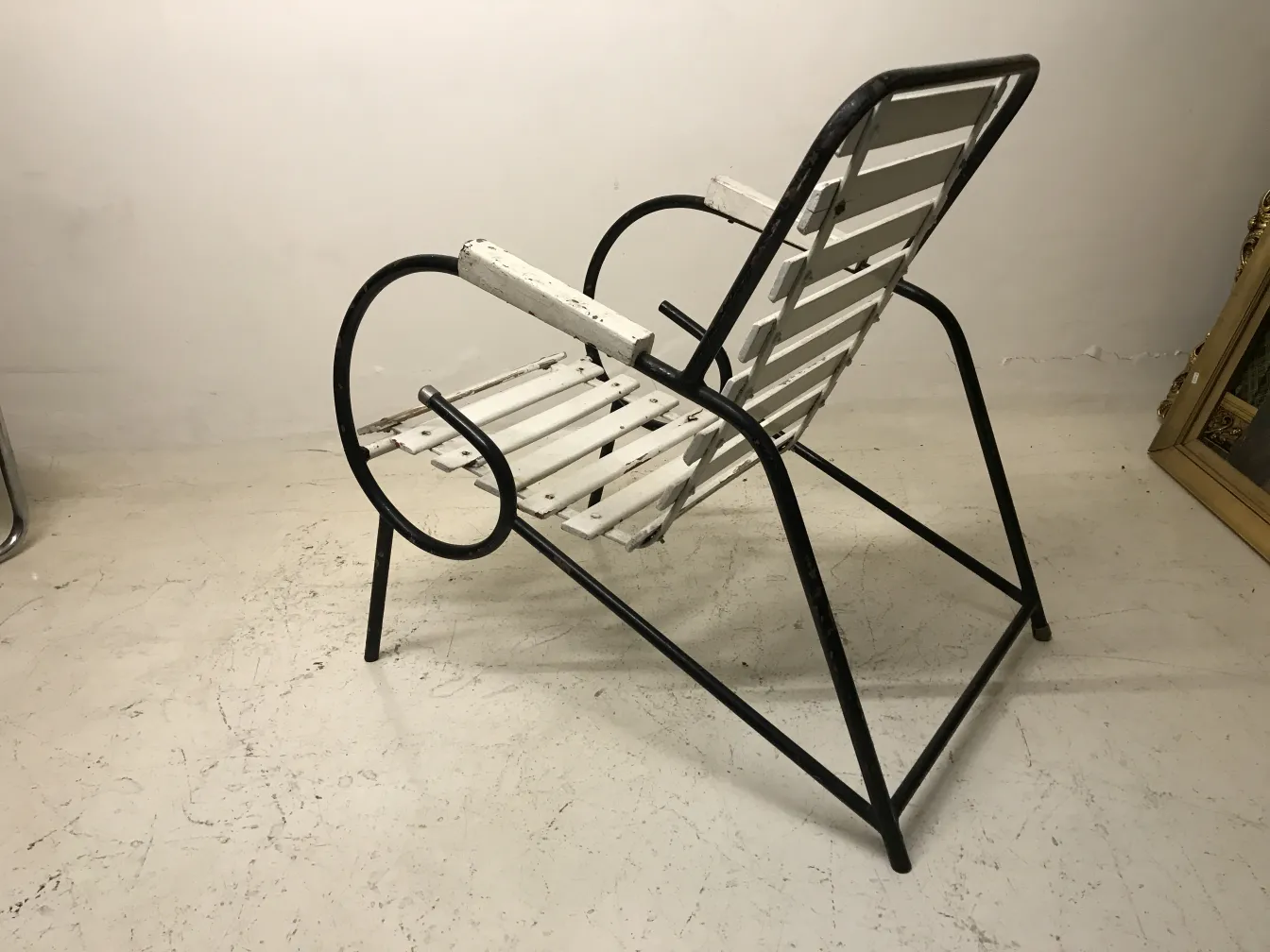 흰색 마감과 금속 구조를 가진 고대 정원 안락의자가 중립적인 환경에 배치되어 있습니다。