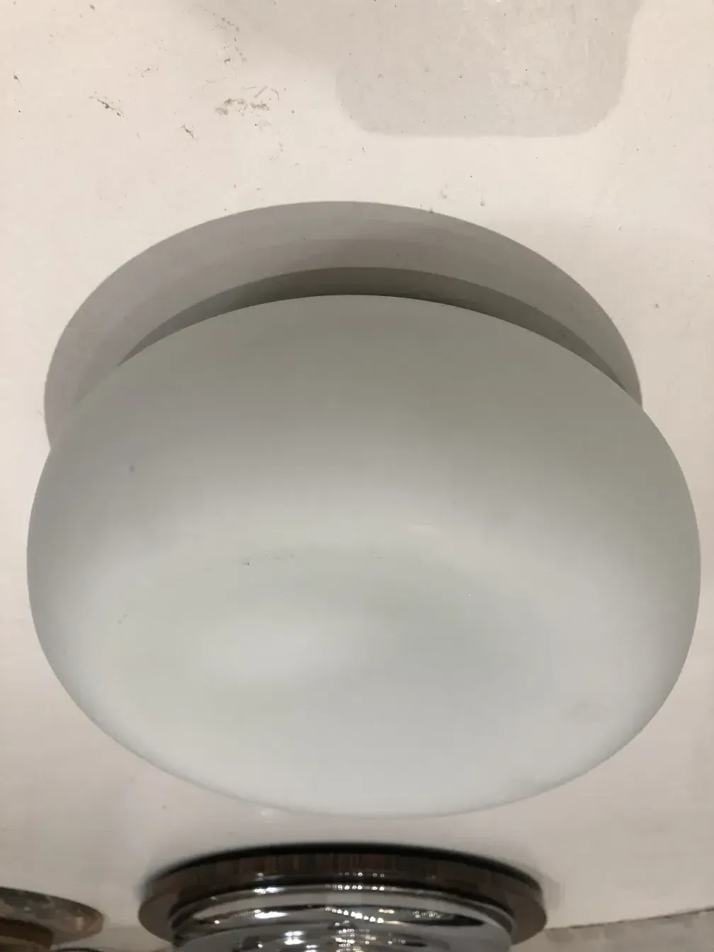 plafoniera antica rotonda con design semplice in un ambiente scuro